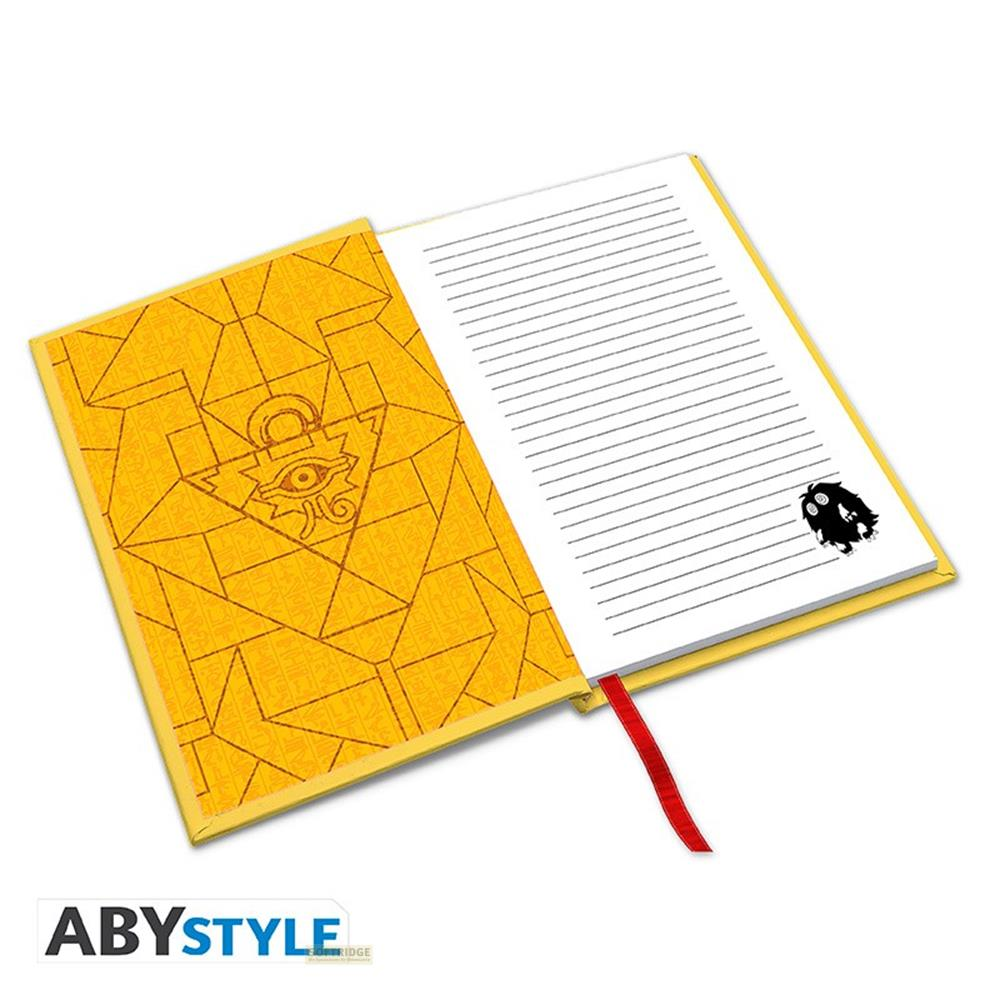 Un carnet jaune à motif égyptien avec un marque-page rouge.