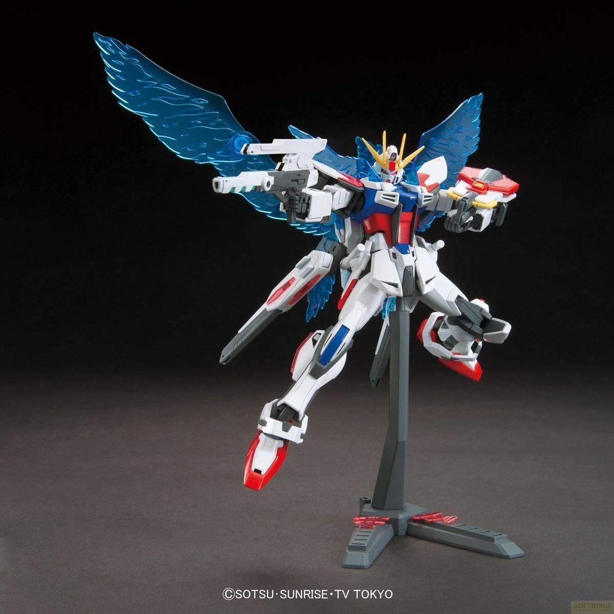 Un modèle Gundam blanc, rouge et bleu avec des ailes bleues translucides et des armes, posé dynamiquement sur un support gris.