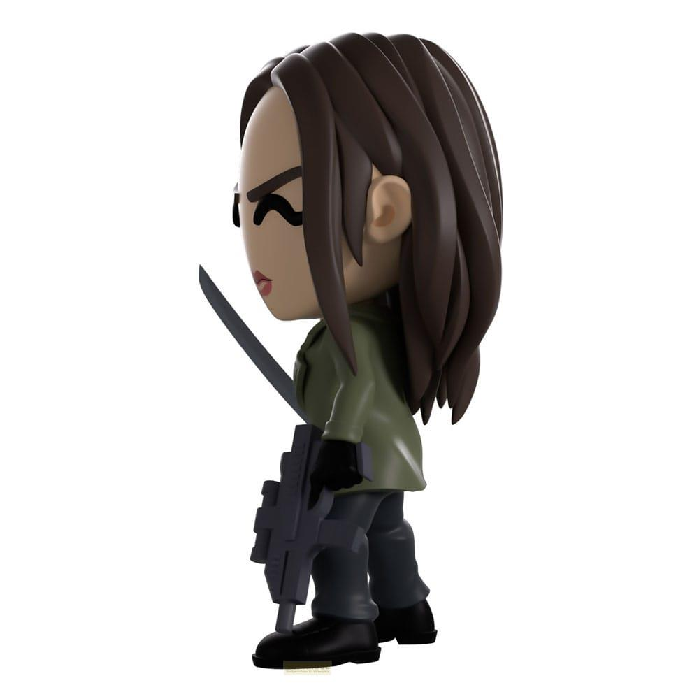 Eine Miniaturfigur mit braunem Haar, die eine grüne Jacke und Hose trägt, hält eine Waffe und ein Schwert.