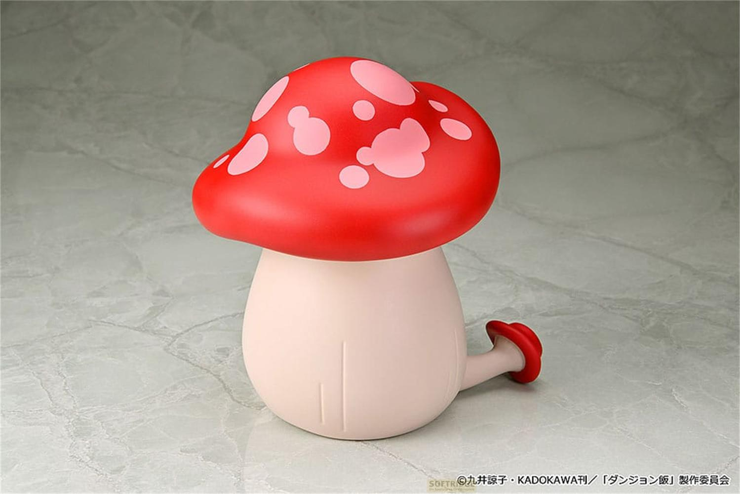 Una figura di fungo rosso con macchie rosa chiaro su un pavimento di marmo grigio.
