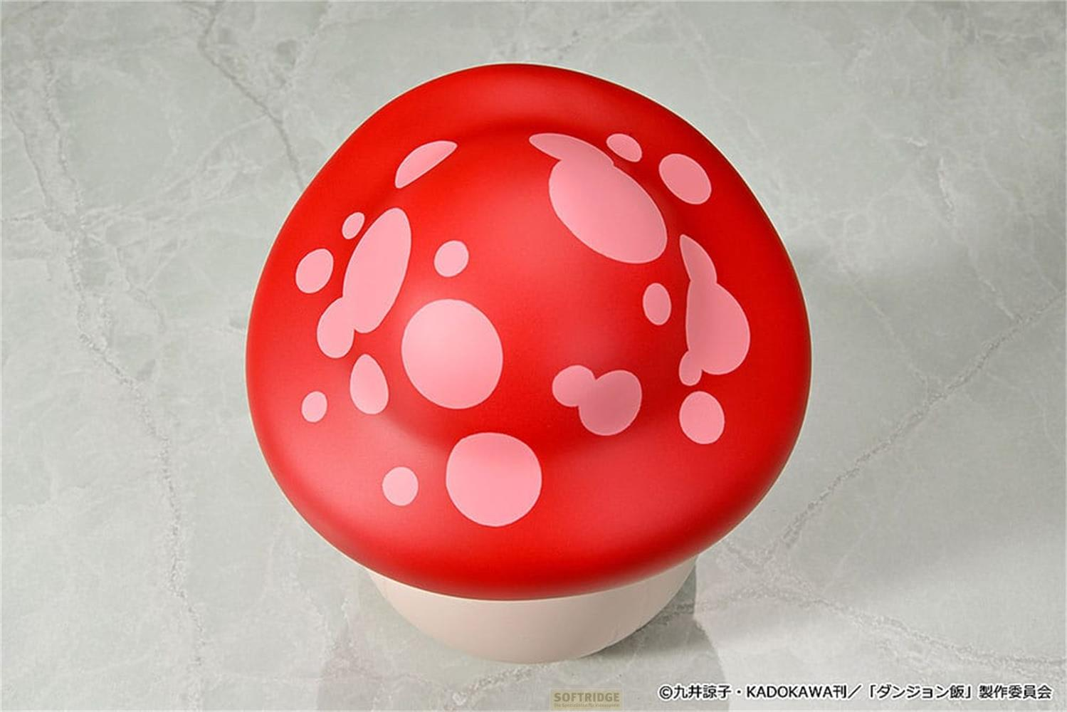 Un fungo rosso con macchie rosa chiaro su sfondo chiaro.