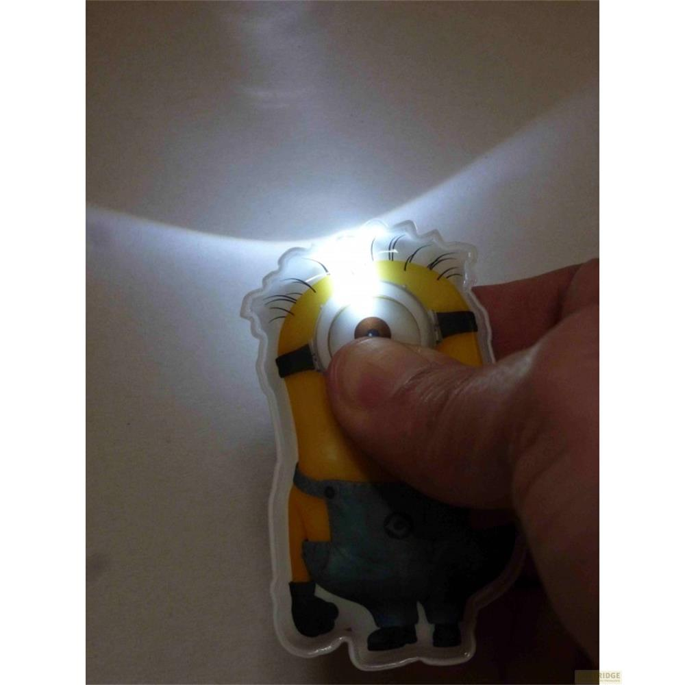 Un porte-clés Minion avec lampe de poche œil lumineux est tenu par une main.