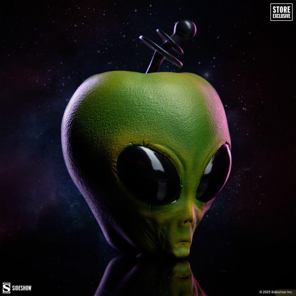 Grüner Alien-Kopf mit großen schwarzen Augen auf Sternenhintergrund.