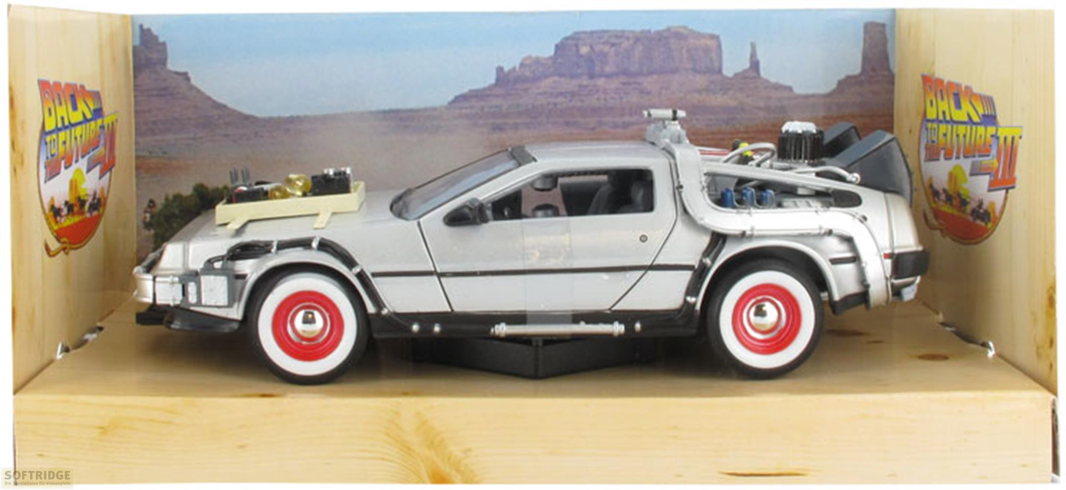 Un modèle DeLorean argenté avec des jantes rouges sur une surface en bois.