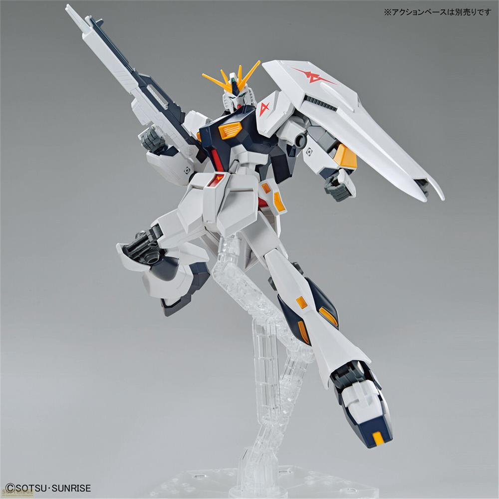 Ein weißer Gundam-Roboter hält eine Waffe und einen Schild.