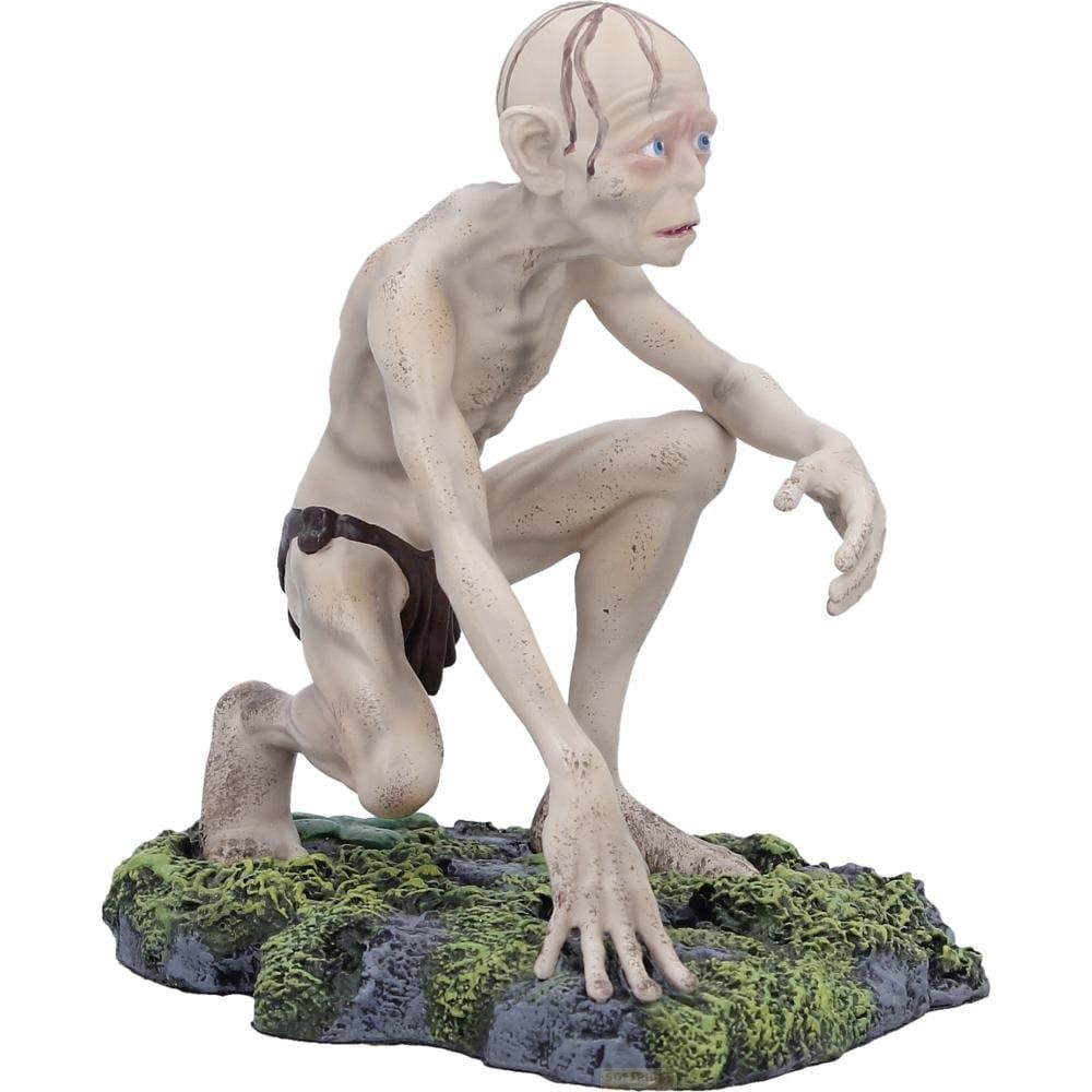 Gollum kauert auf einem felsigen, moosbewachsenen Untergrund mit weißem Hintergrund.