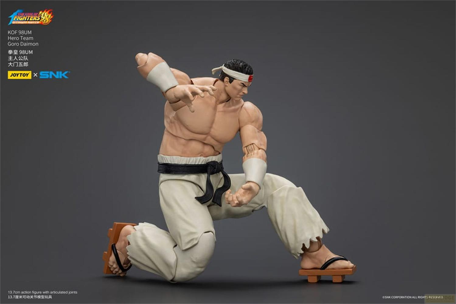 Un action figure di Goro Daimon in abiti bianchi si inginocchia a terra.
