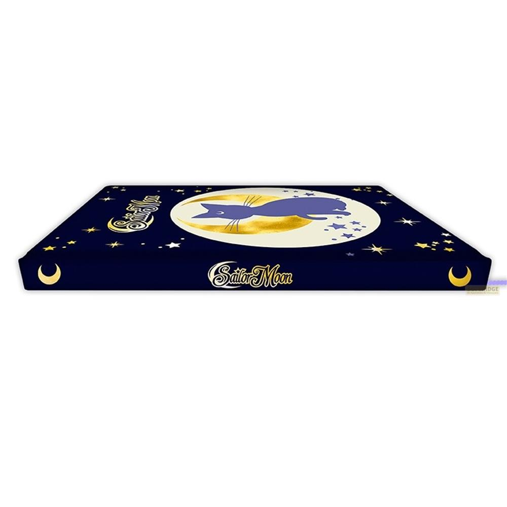 Boîte bleu foncé avec logo Sailor Moon, lune, chat et étoiles.