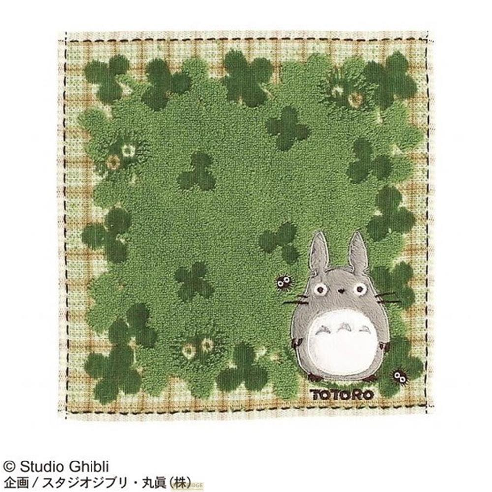 Totoro et petites créatures noires sur fond vert à motif trèfle.