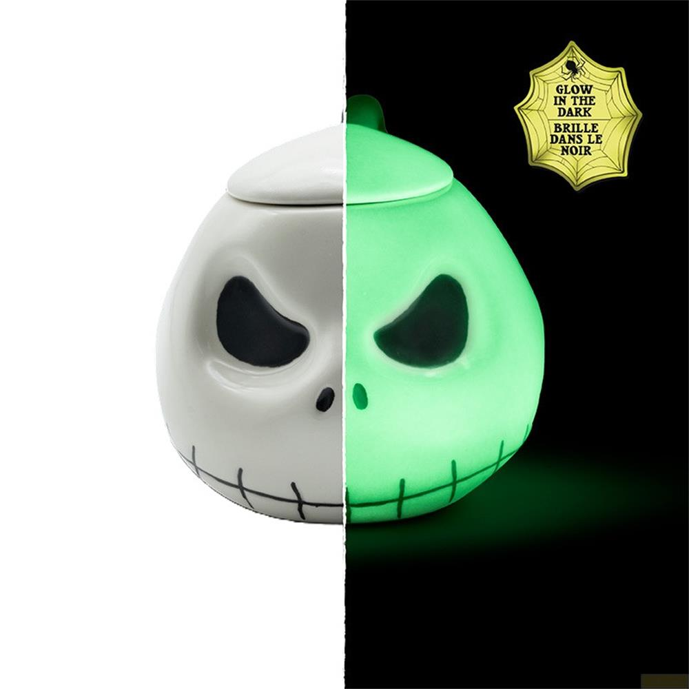 Media calabaza con diseño de calavera brilla en verde, la otra mitad es blanca.