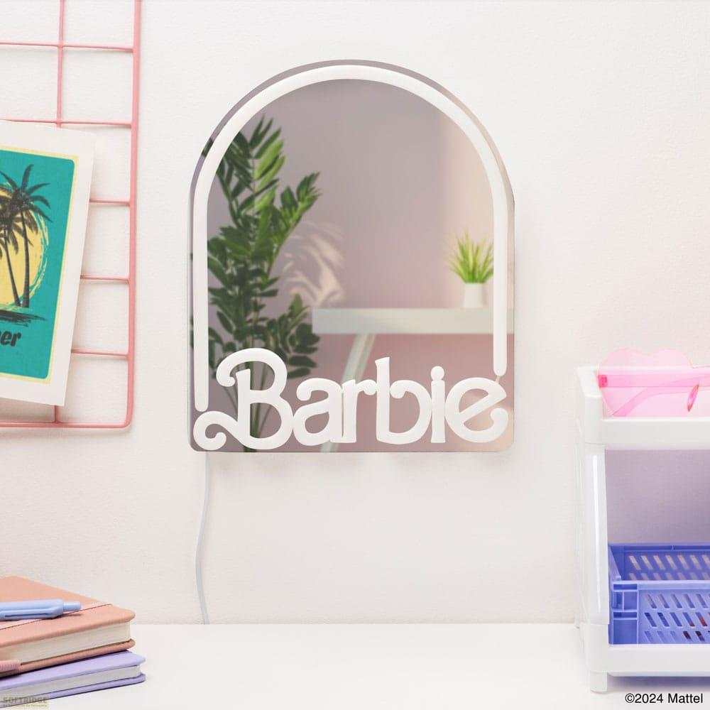 Ein Barbie-Spiegel mit einem Schriftzug, daneben ein Bild und Bücher.