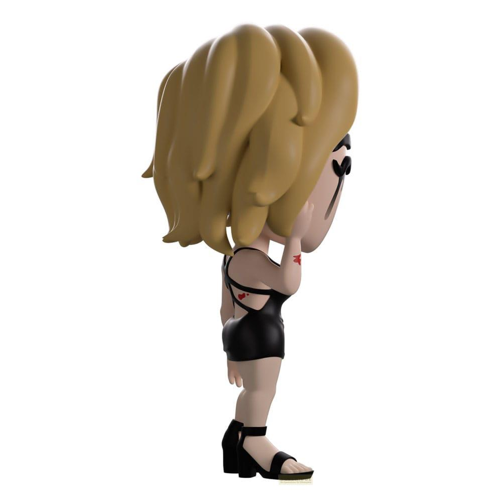 Una figurita con pelo rubio, vestido negro y tacones altos.