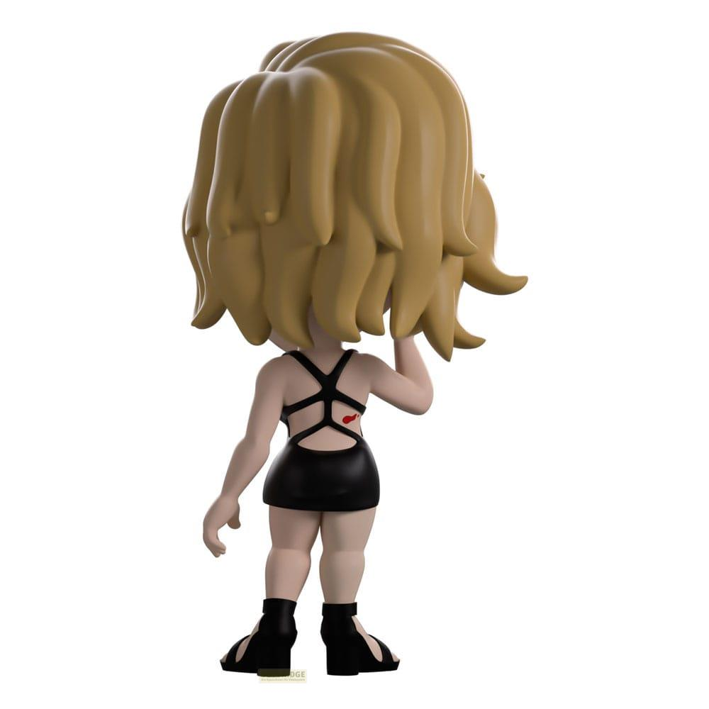 Una figura de cabello rubio con vestido negro, vista desde atrás.