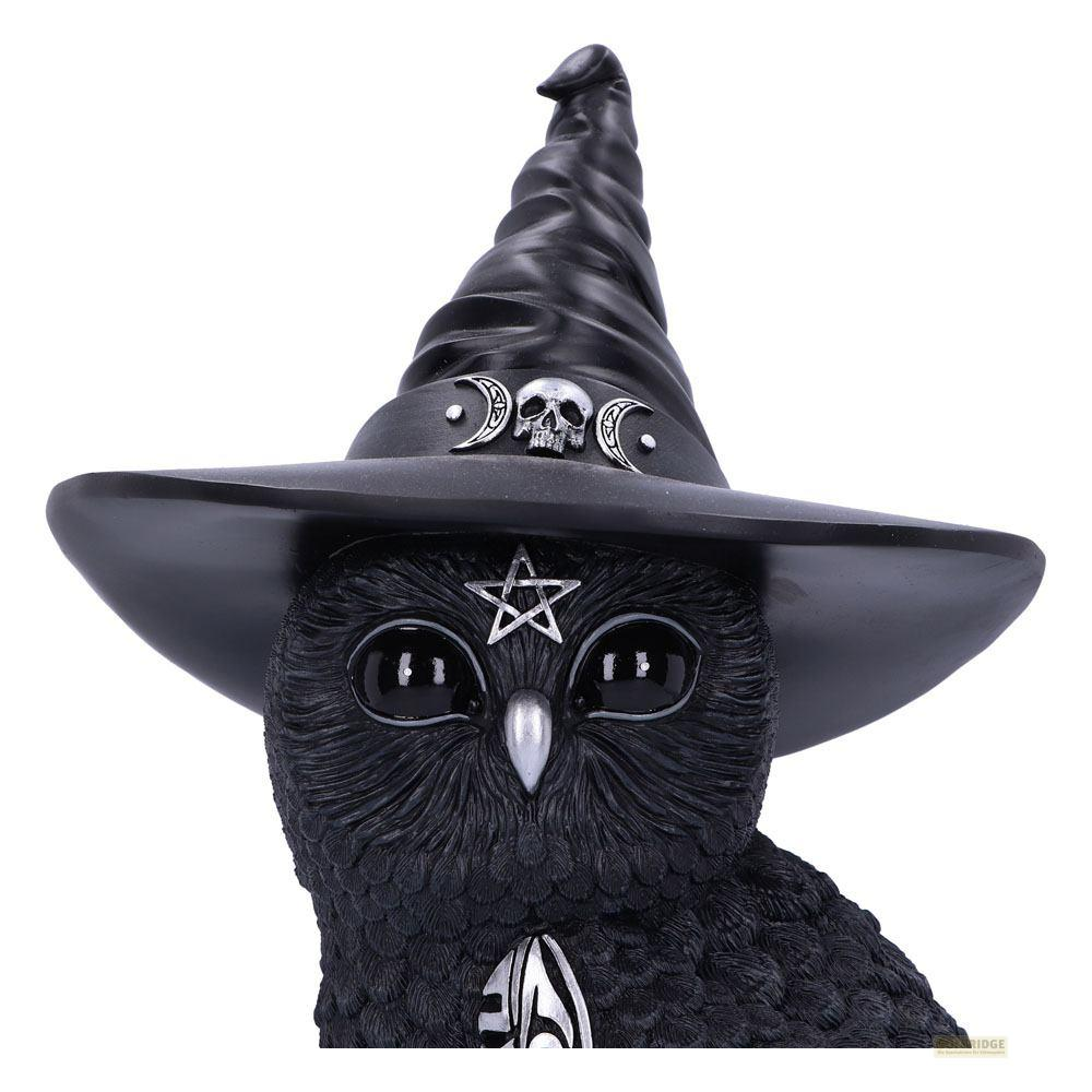 Figura de búho negro con sombrero de bruja adornado con lunas y calaveras.