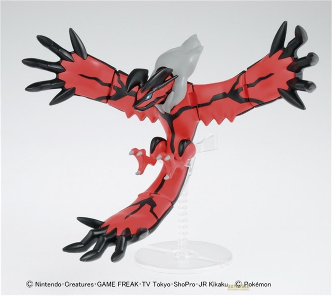Une figurine Pokémon rouge et noire aux ailes déployées, sur un support.