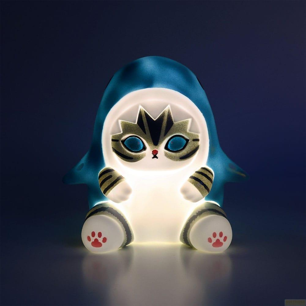 Eine leuchtende Katze in einem blauen Hai-Kostüm sitzt.