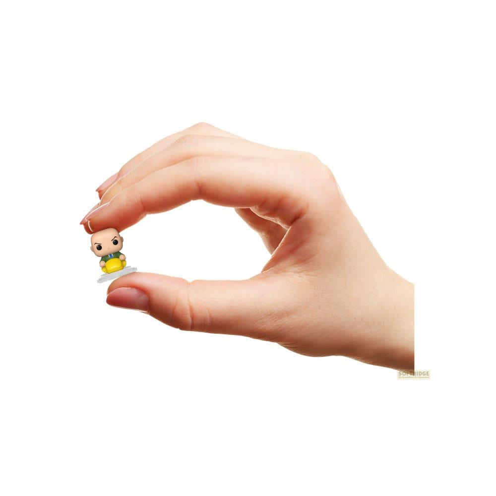 Eine Hand hält eine kleine Figur mit Glatze und gelb-grünem Outfit.