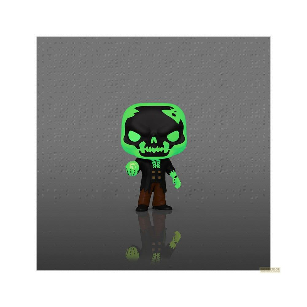 Una figura de calavera verde y negra con pantalones marrones, bajo un foco.