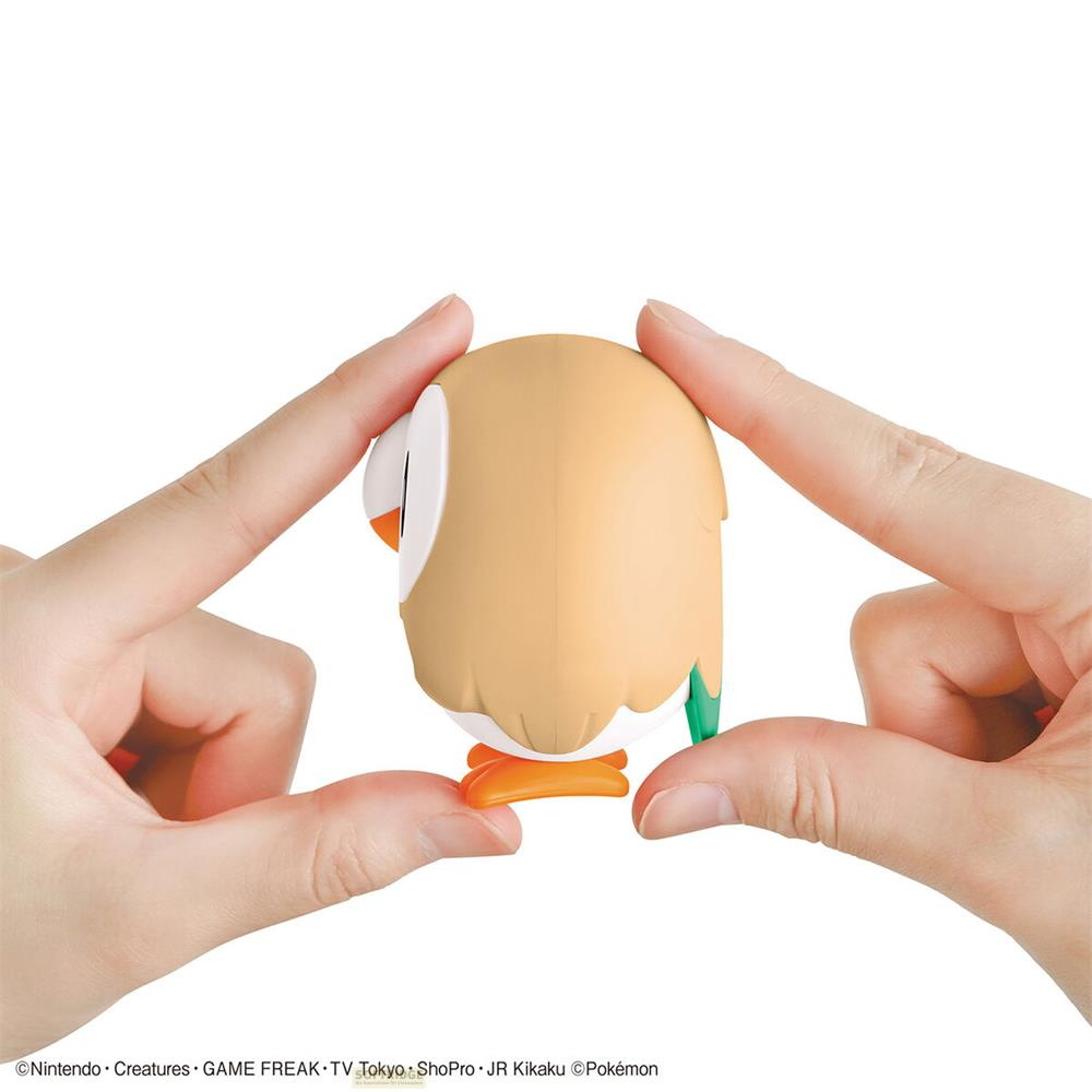 Une figurine beige aux yeux blancs tenue entre des doigts.