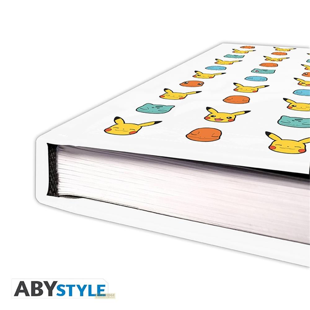 Ein weißes Notizbuch mit Pikachu-Gesichtern und orangefarbenen Kreisen.