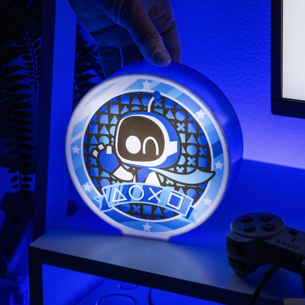 Lampa Astro Bot z symbolami PlayStation, trzymana przez rękę.