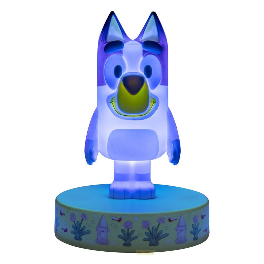 Świecąca figurka Bluey z niebieskim światłem na jasnoniebieskiej podstawie z kwiatami.