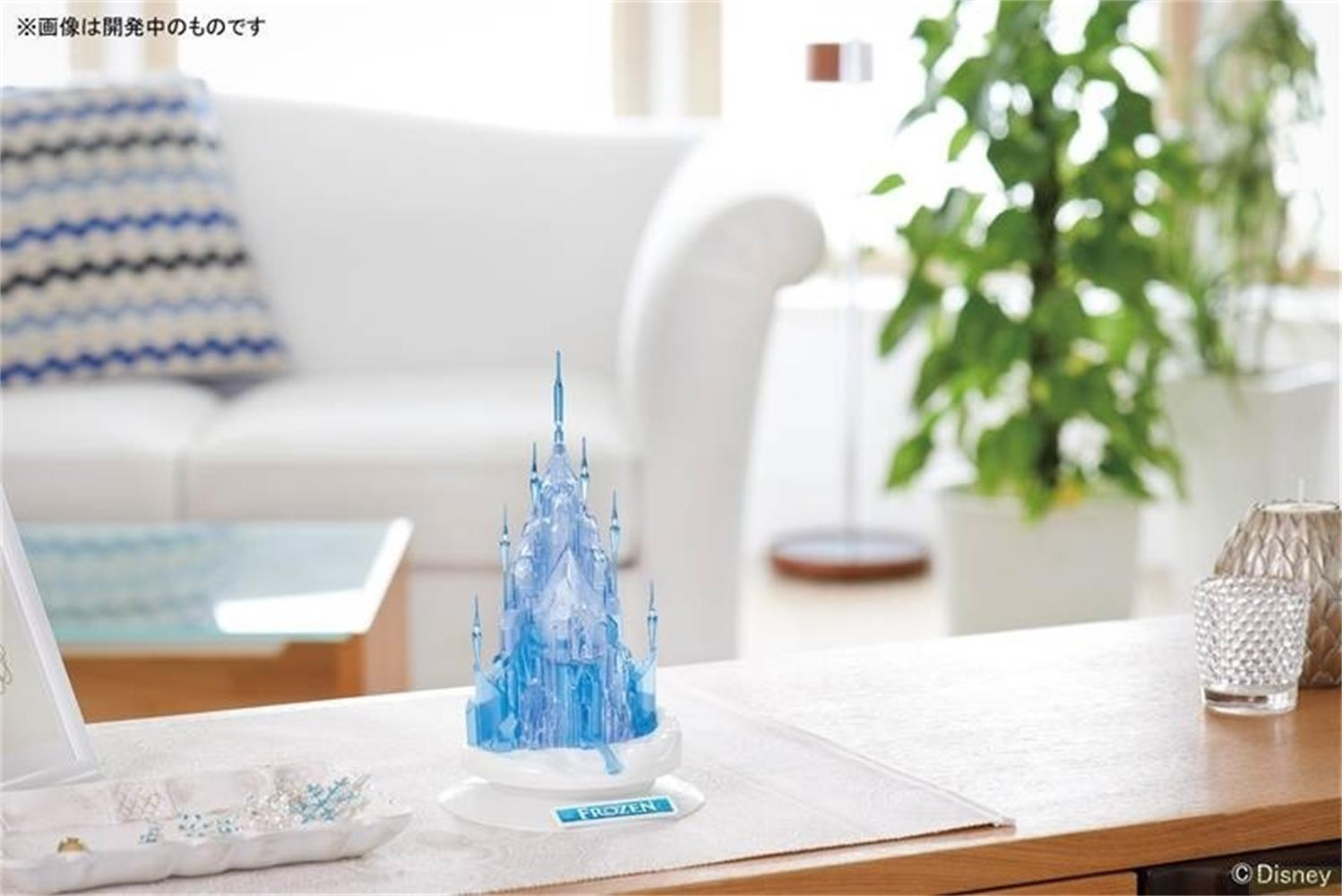 Un château bleu transparent est sur une table à côté de bijoux.