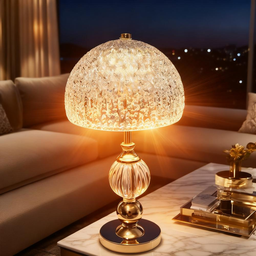Eine goldene Lampe mit strukturiertem Glaslampenschirm steht auf einem Marmortisch.