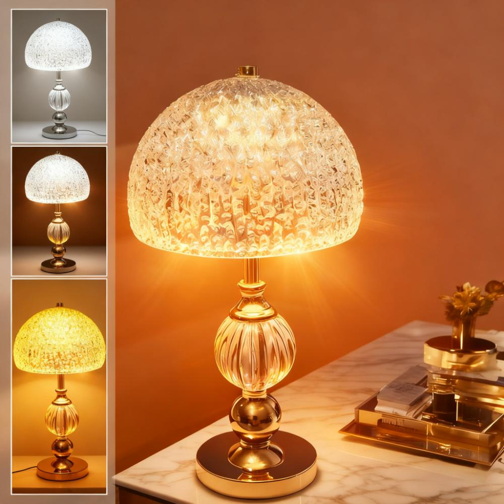 Eine glamouröse Tischlampe mit einem geschwungenen Glaslampenschirm und einem goldenen Sockel.