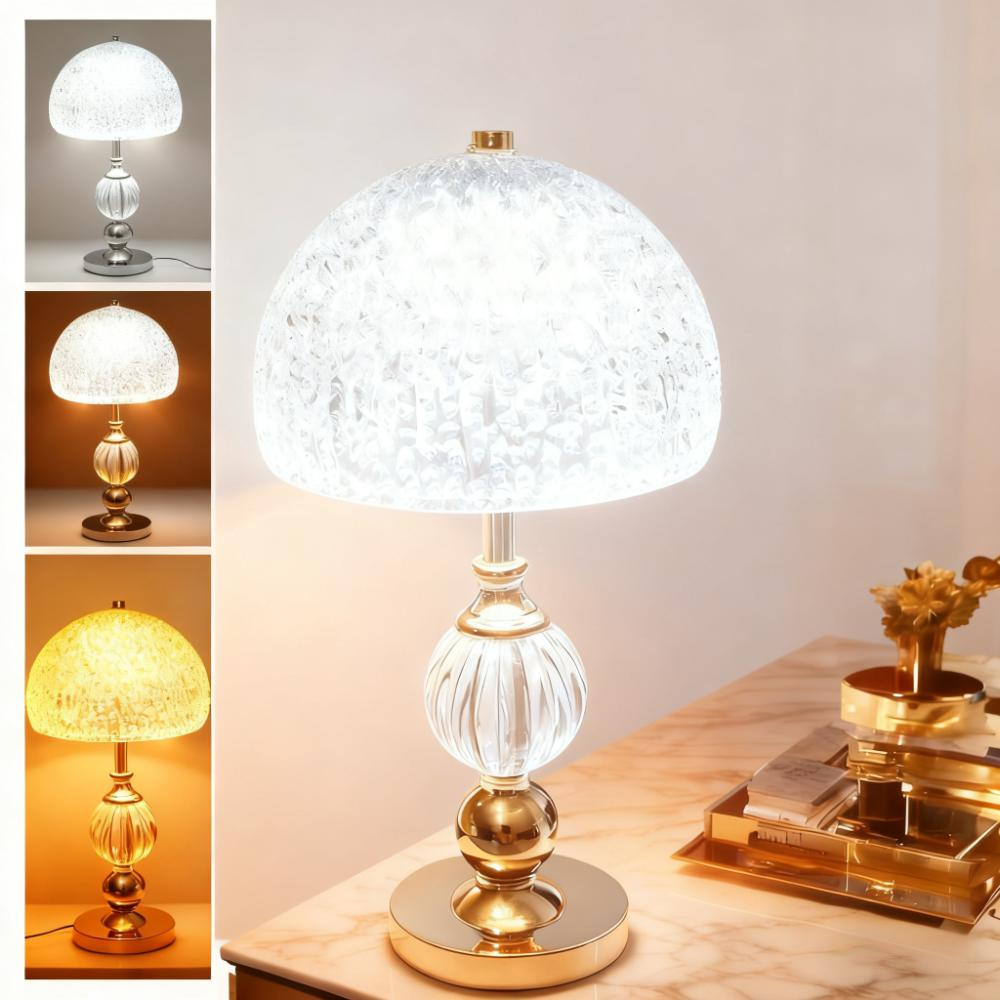 Eine Tischlampe mit einem strukturierten weißen Lampenschirm und einem Glasfuß.