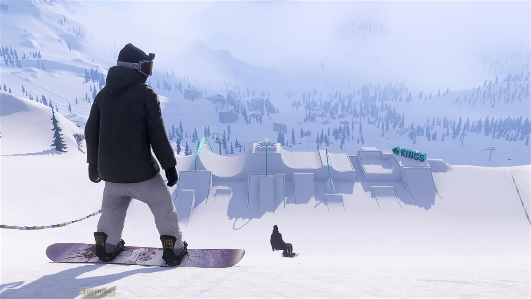 Uno snowboarder guarda una rampa da snowpark con la scritta KINGS.