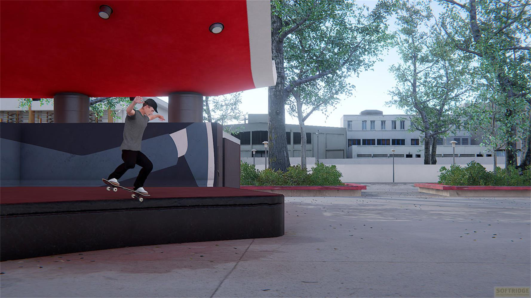 Un skateur saute par-dessus une bordure devant un bâtiment.