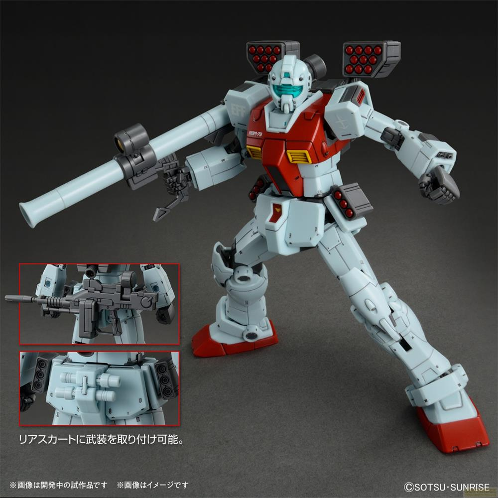 Un robot Gundam blanc et rouge tenant un fusil. Les détails insérés montrent un fusil et un lance-missiles.