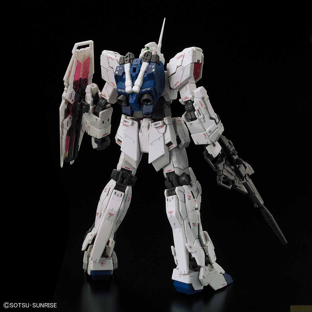 Ein weißer Gundam-Roboter mit blauem Rumpf und Waffe steht.