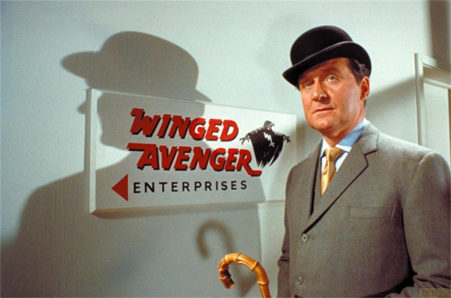 Uomo con bombetta e completo accanto all'insegna 'Winged Avenger Enterprises'.