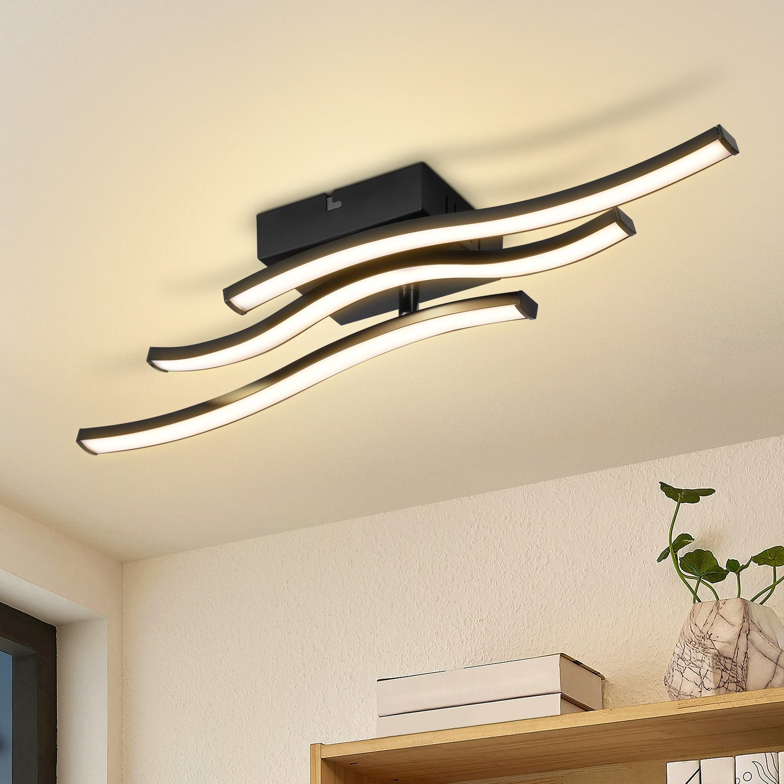 Lampada da soffitto moderna con bracci curvi e luce LED su sfondo crema.