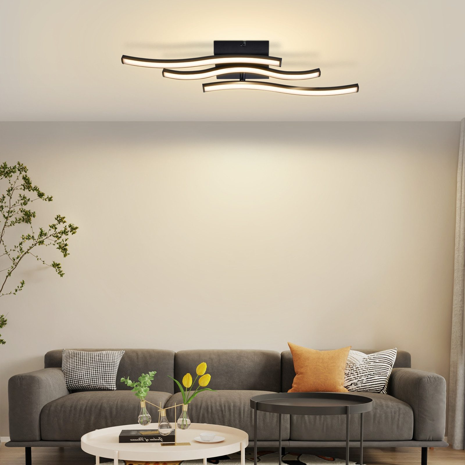 Un soggiorno moderno con divano grigio, tavolini e lampada da soffitto curva.