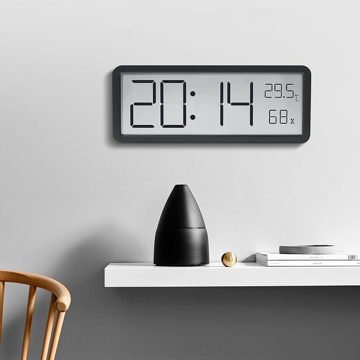 Digitaluhr zeigt 20:14, 29.5C, 68%. Schwarzer Kegel, goldene Kugel auf Regal.