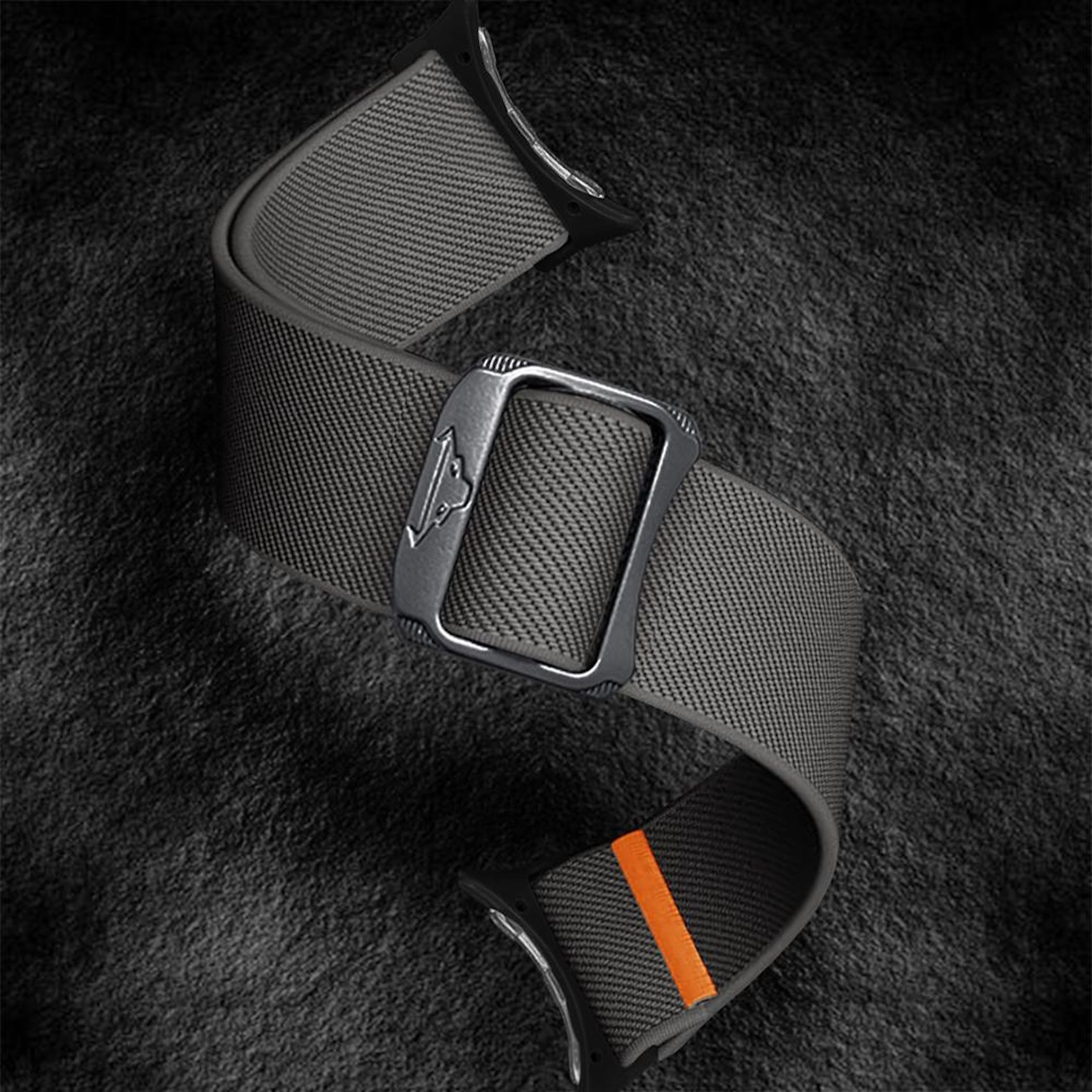 Graues Armband mit Metallschnalle und orangefarbenem Streifen auf schwarzem Hintergrund.