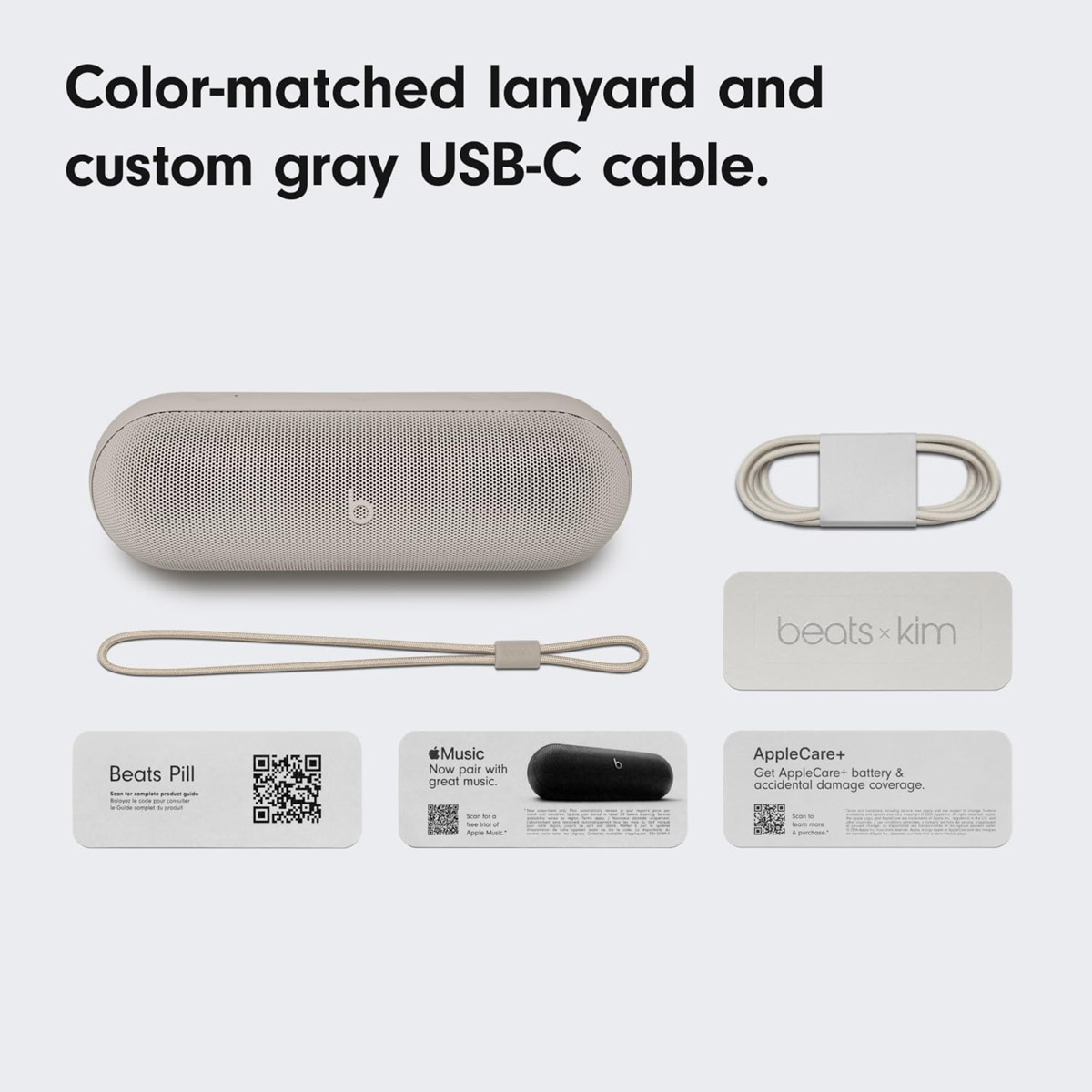 Een beige Beats Pill speaker met bijpassend koord en grijze USB-C kabel.