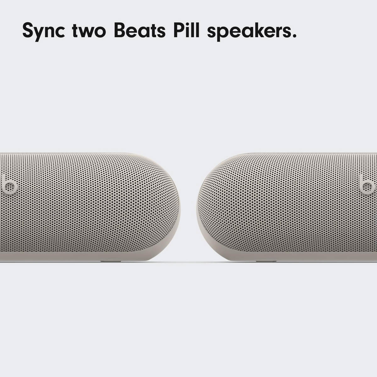 Twee witte Beats Pill luidsprekers staan naast elkaar.