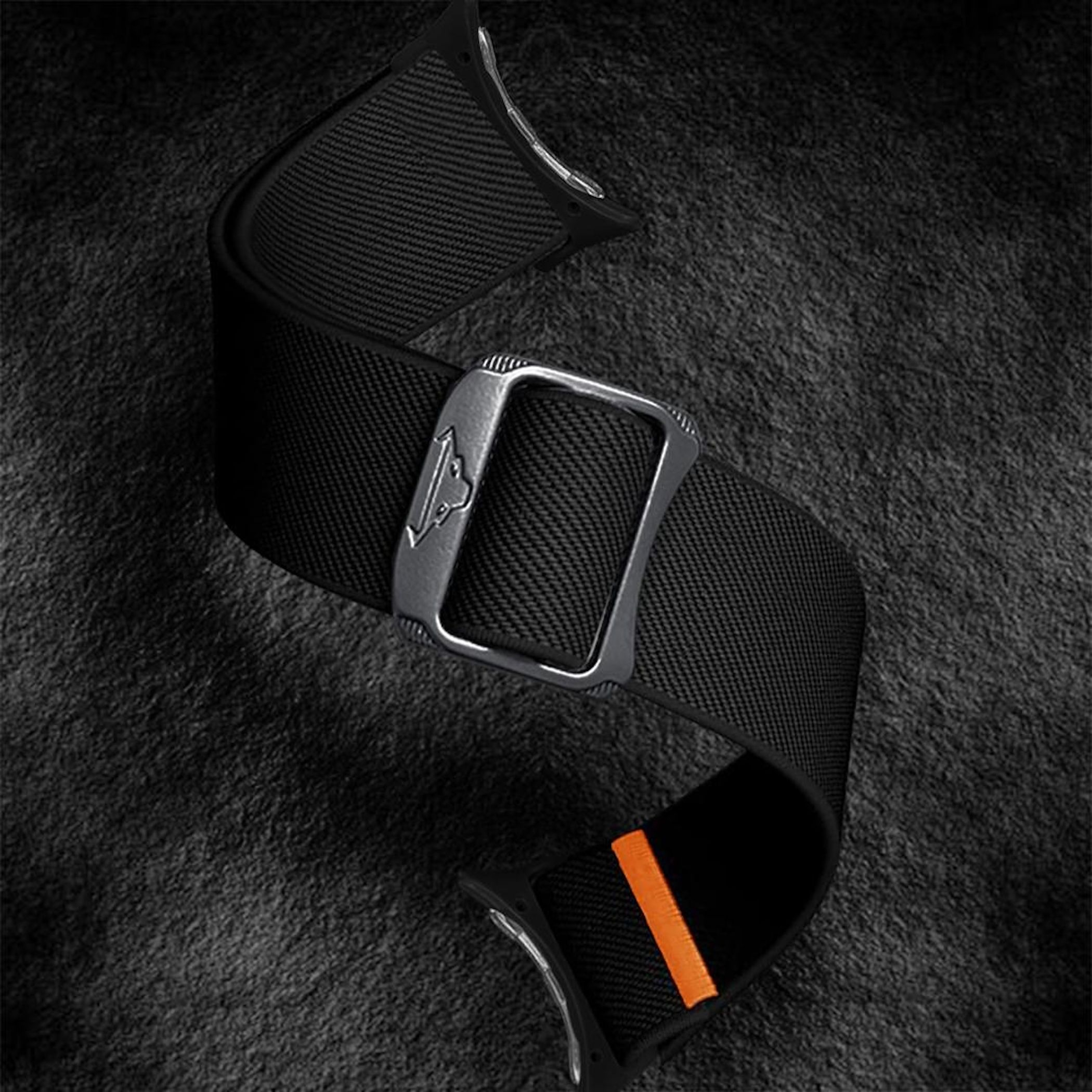 Ein schwarzes Uhrenarmband mit strukturierter Oberfläche und einer gebürsteten Metallschnalle mit kleinem Emblem auf dunklem, strukturiertem Hintergrund.