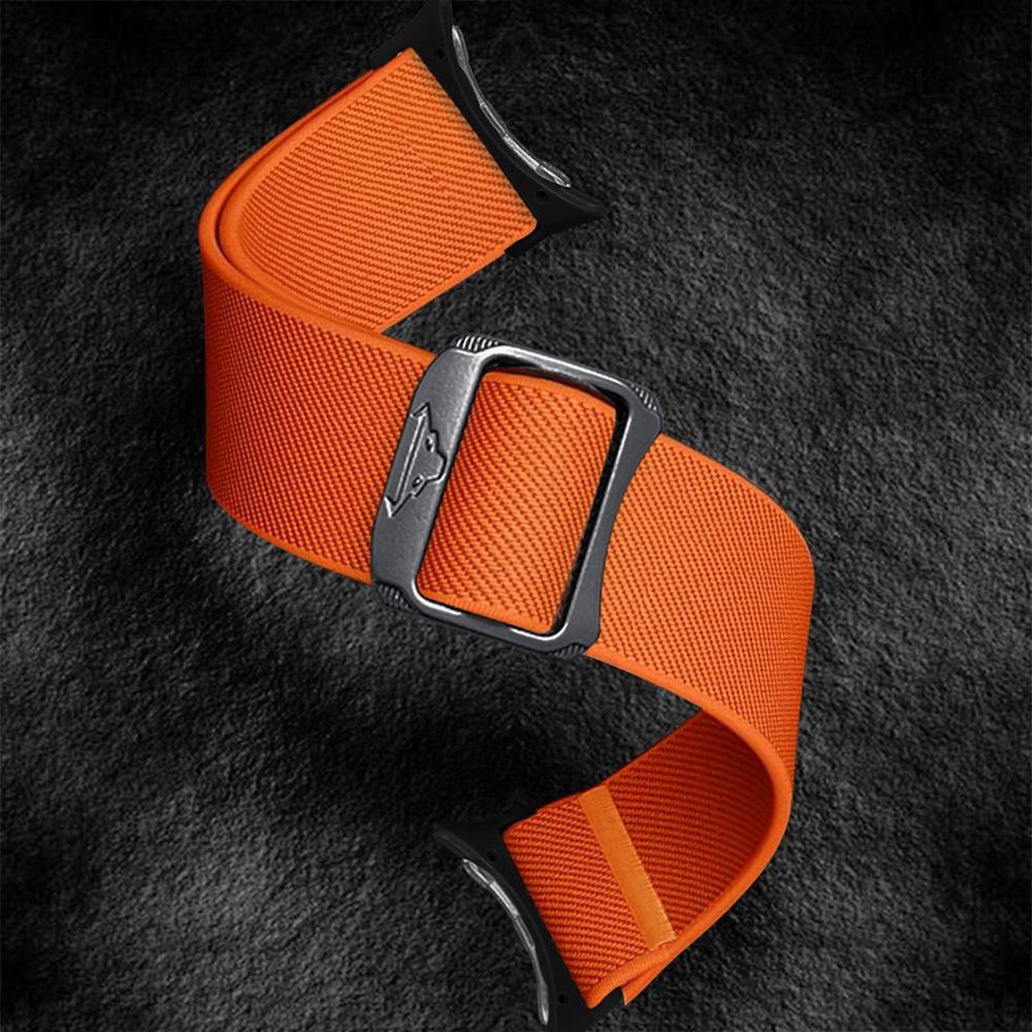 Ein orangefarbenes Uhrenarmband mit Metallschnalle auf schwarzem Grund.