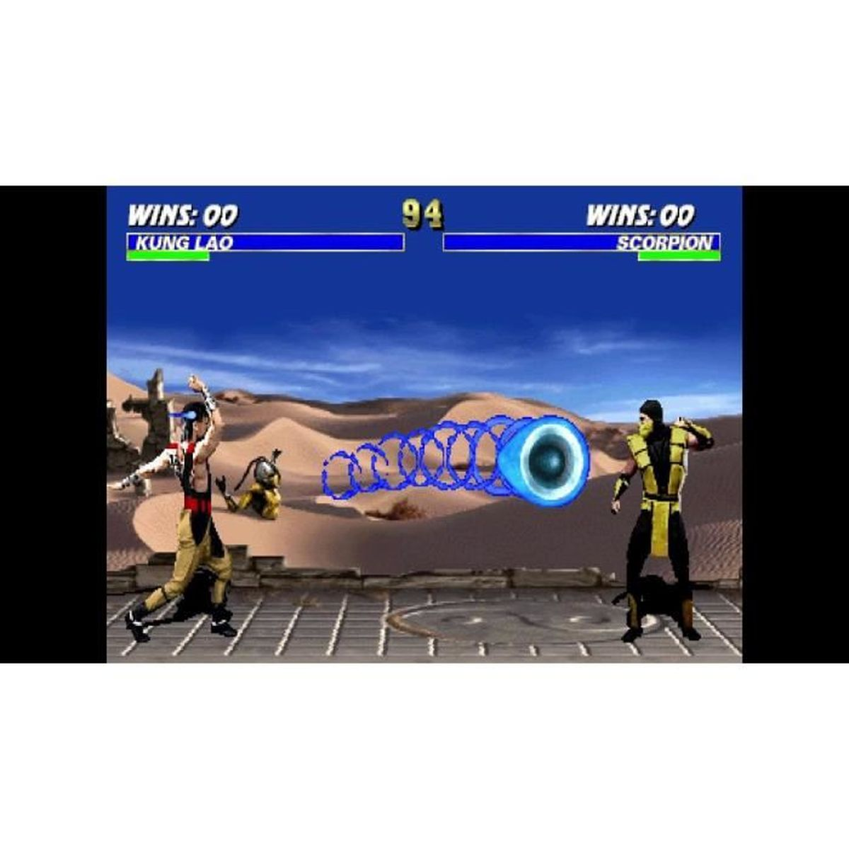 Kung Lao atakuje Scorpiona niebieskim pociskiem energetycznym na pustyni.