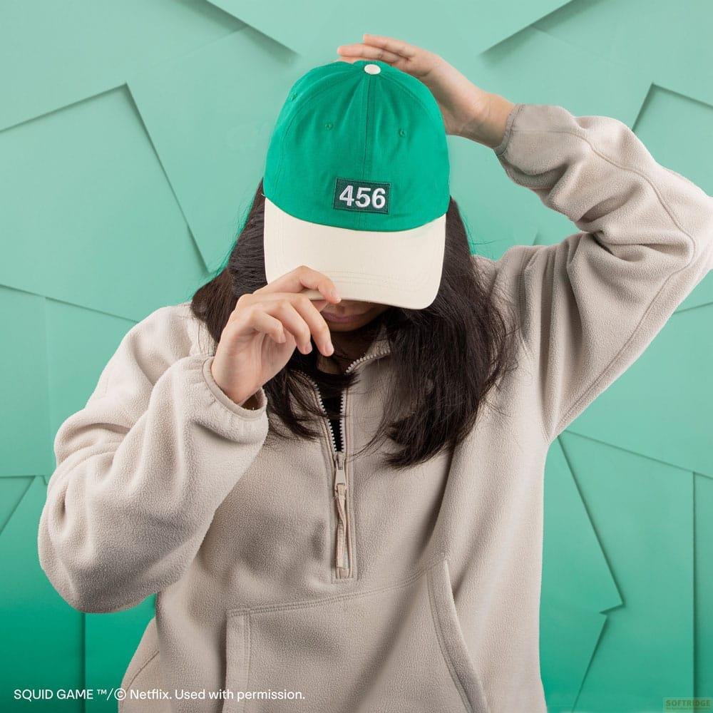 Una persona con gorra verde y crema con el número 456.