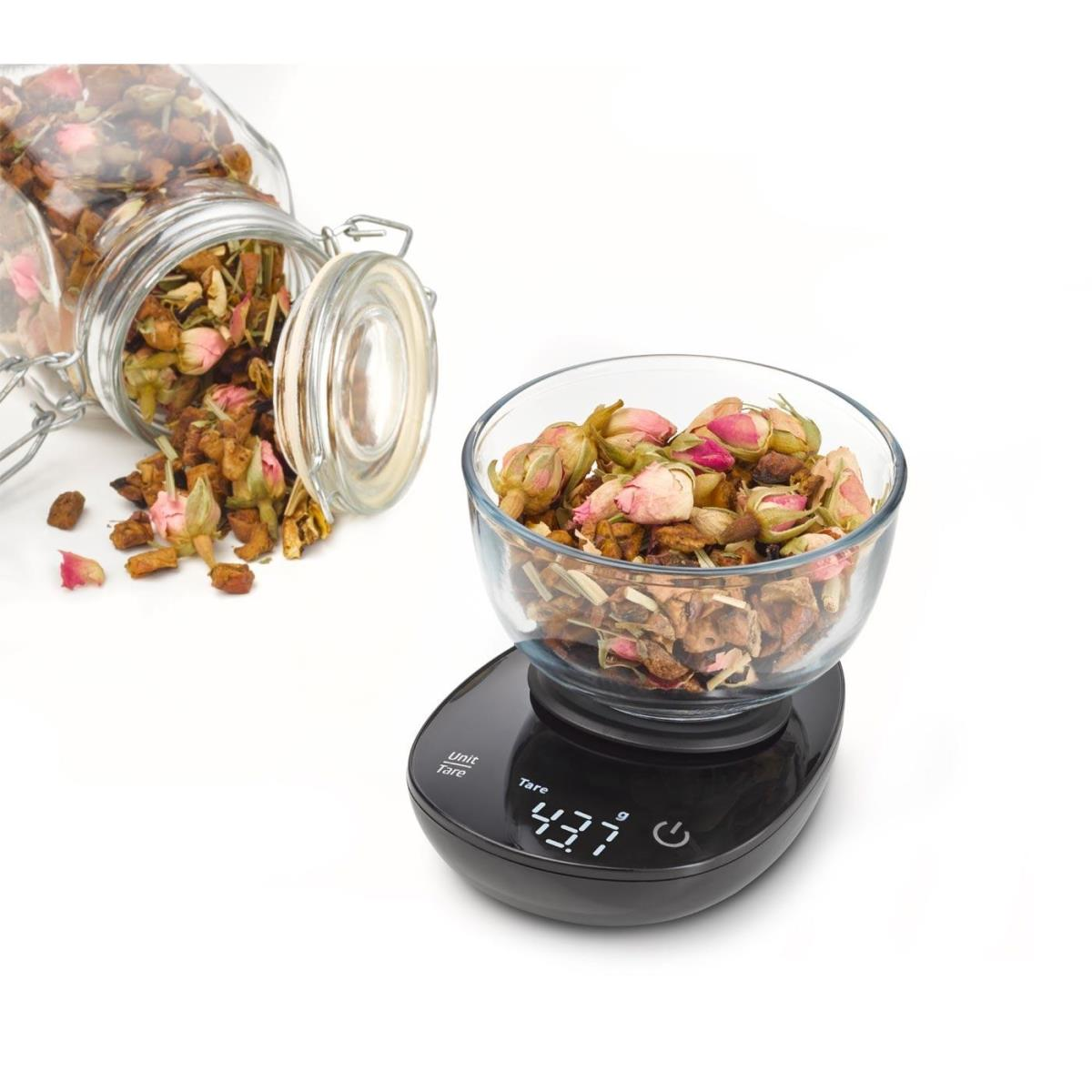 Boutons de rose séchés et herbes dans un bol en verre sur une balance numérique affiche 43,7g.