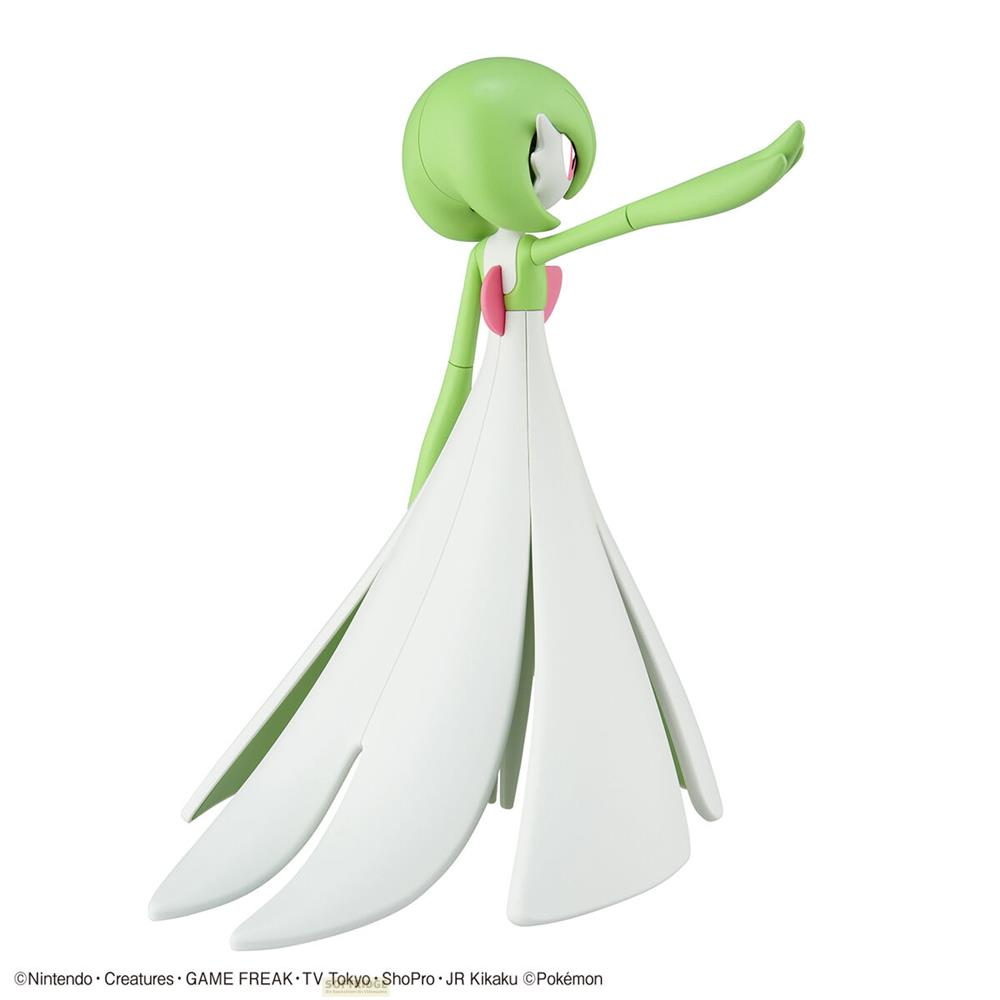 Figurine verte avec robe blanche et bras levé.