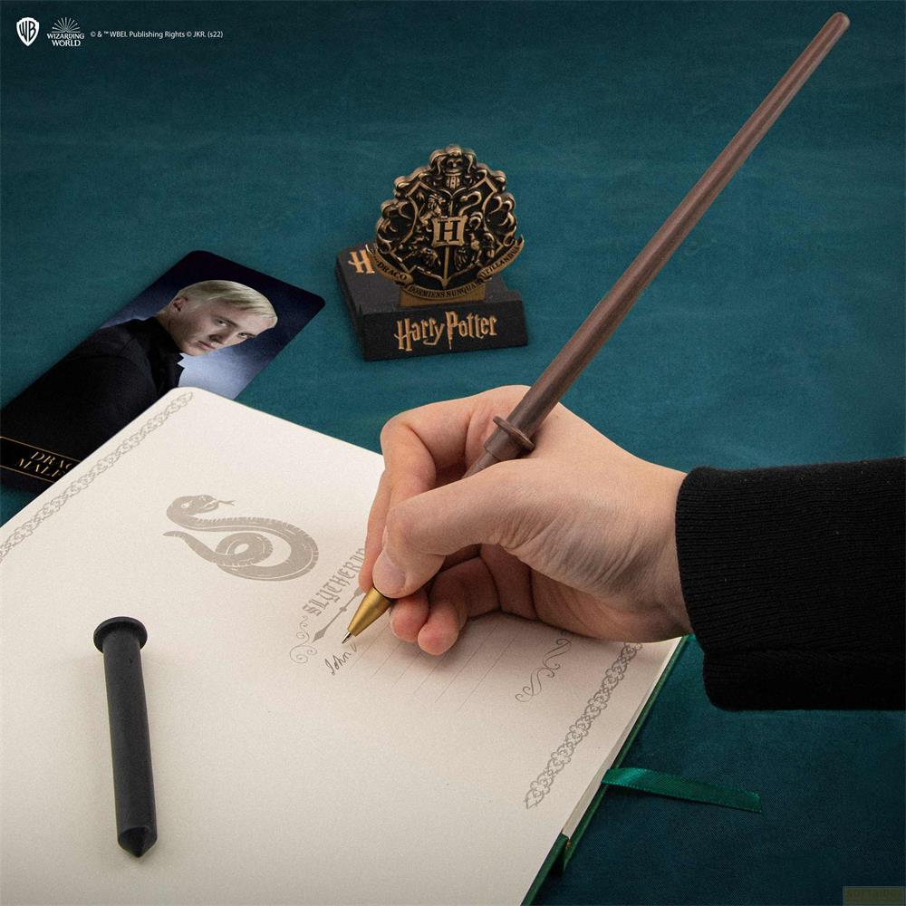 Eine Hand schreibt mit einem Zauberstabstift in ein Harry Potter Notizbuch.