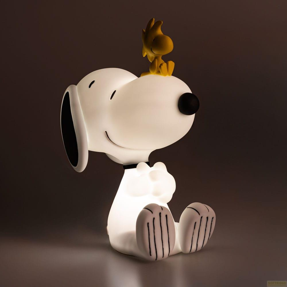 Un Snoopy brillante se sienta con Woodstock en la cabeza sobre un fondo oscuro.