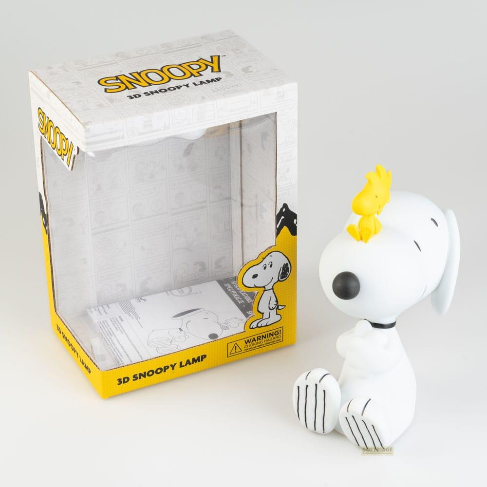 Figura de Snoopy con Woodstock en la cabeza junto a una caja de lámpara Snoopy.